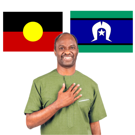 A man standing beneath the Aboriginal and Torres Strait Islander flags with his hand on his chest.