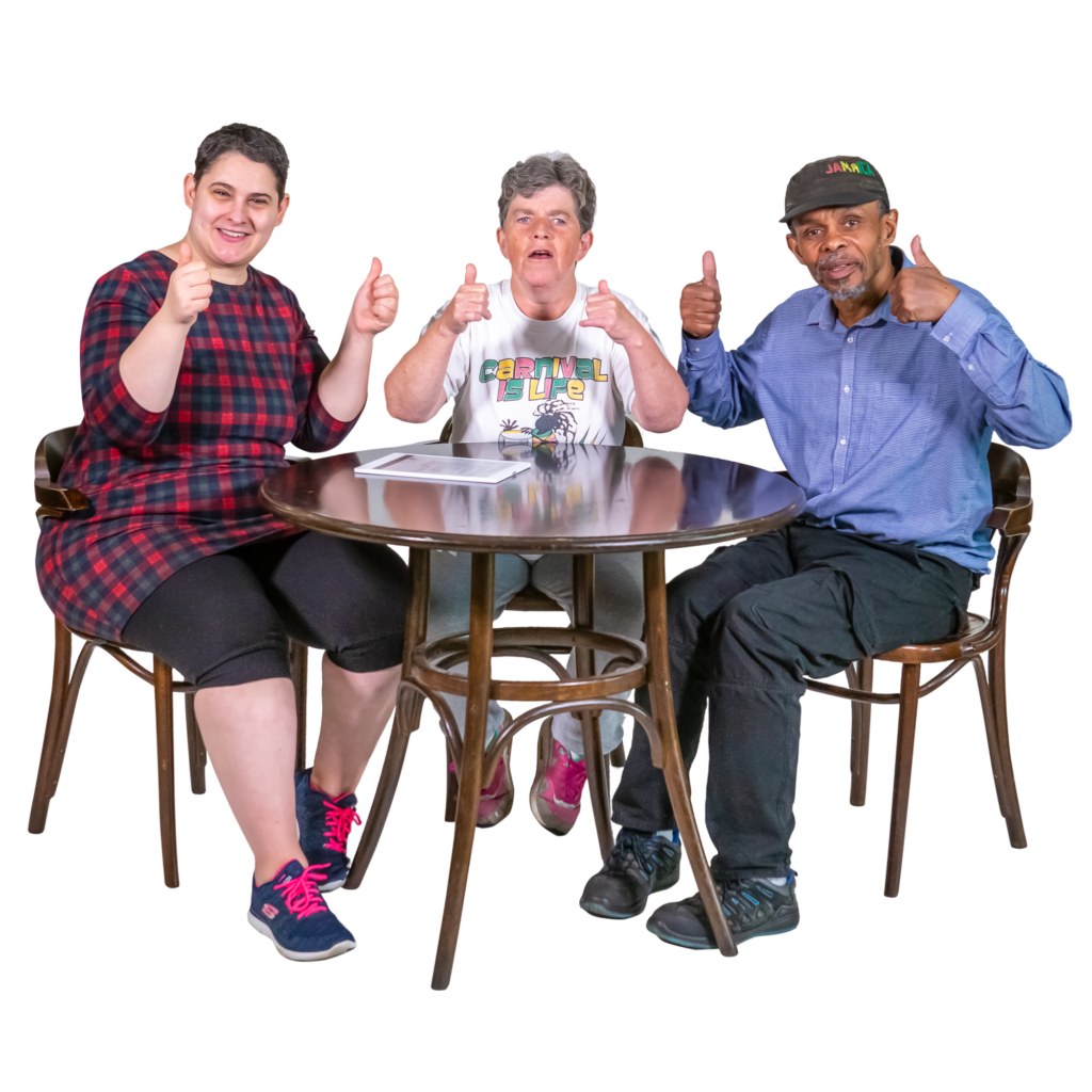 3 people sitting on a table with their thumbs up