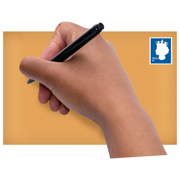 A hand holding a pen and writing on an envelope.