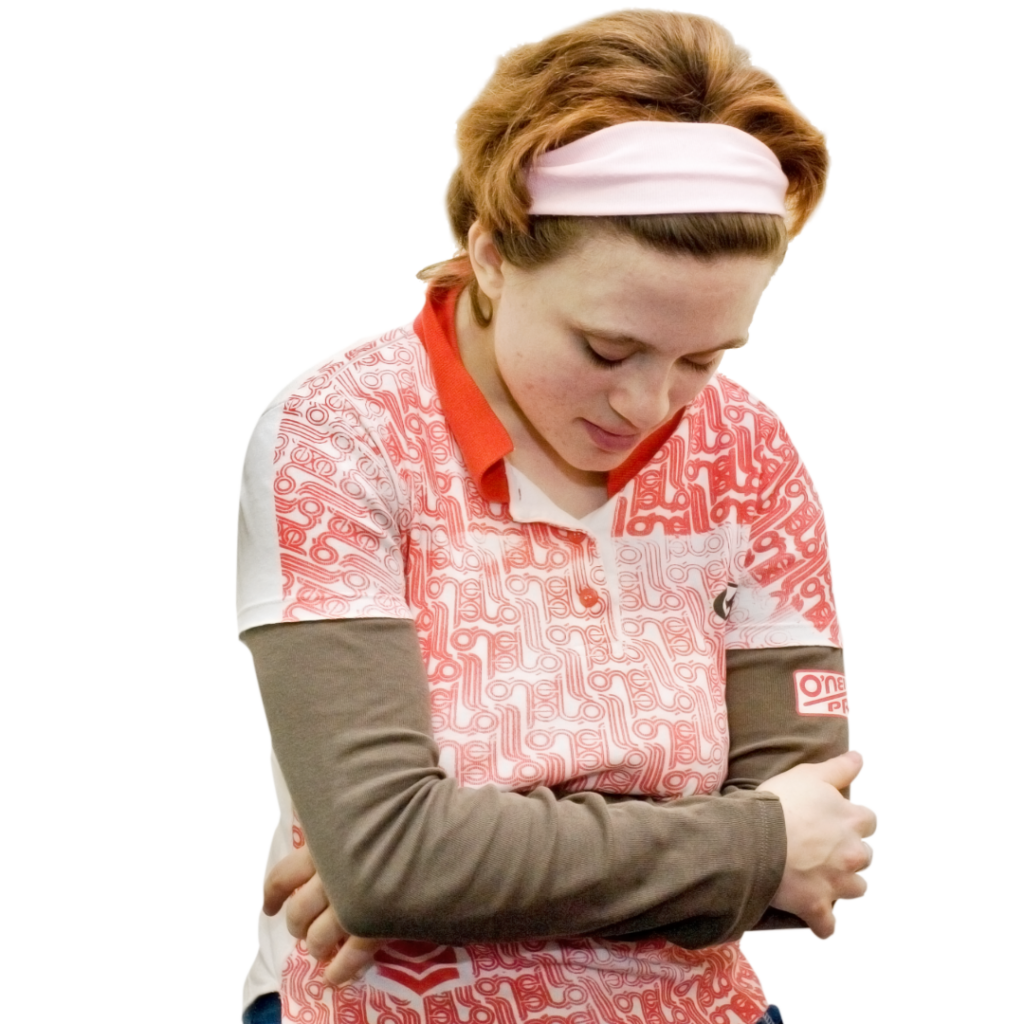 A woman with her arms wrapped around herself, looking downward.