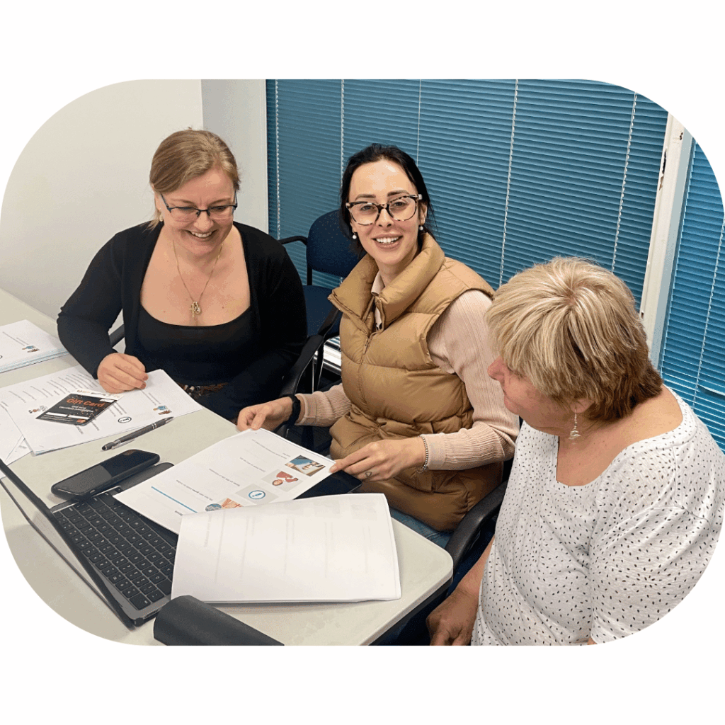 Three women discussing documents together.