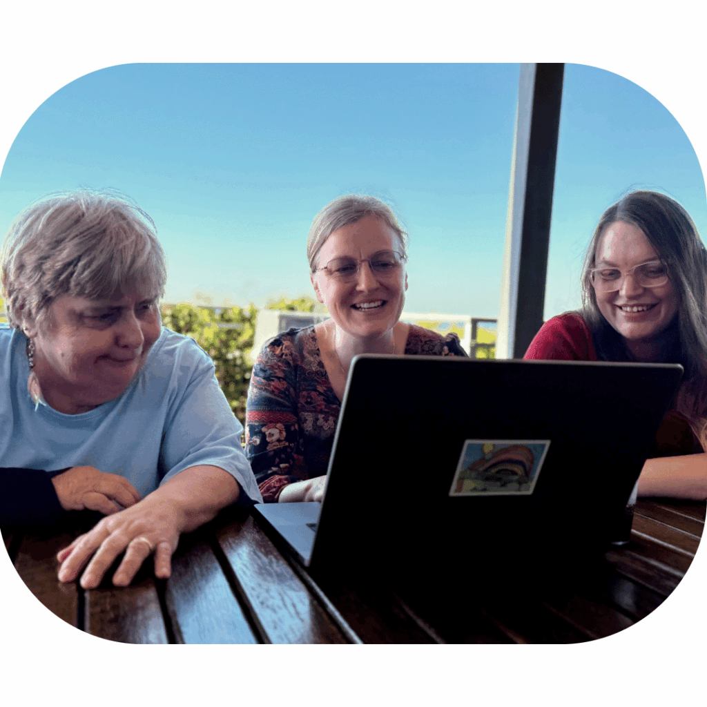 Three women looking at a laptop together.