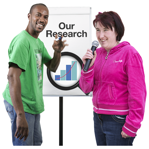 Two people standing next to a flipchart. One holding a microphone