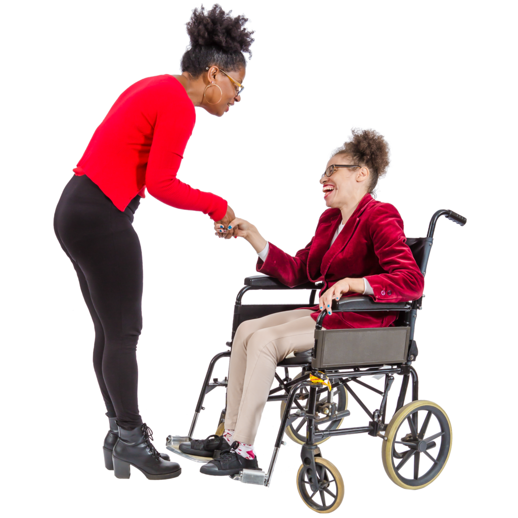 Two women smiling, shaking hands, one standing and one sitting in a wheelchair.